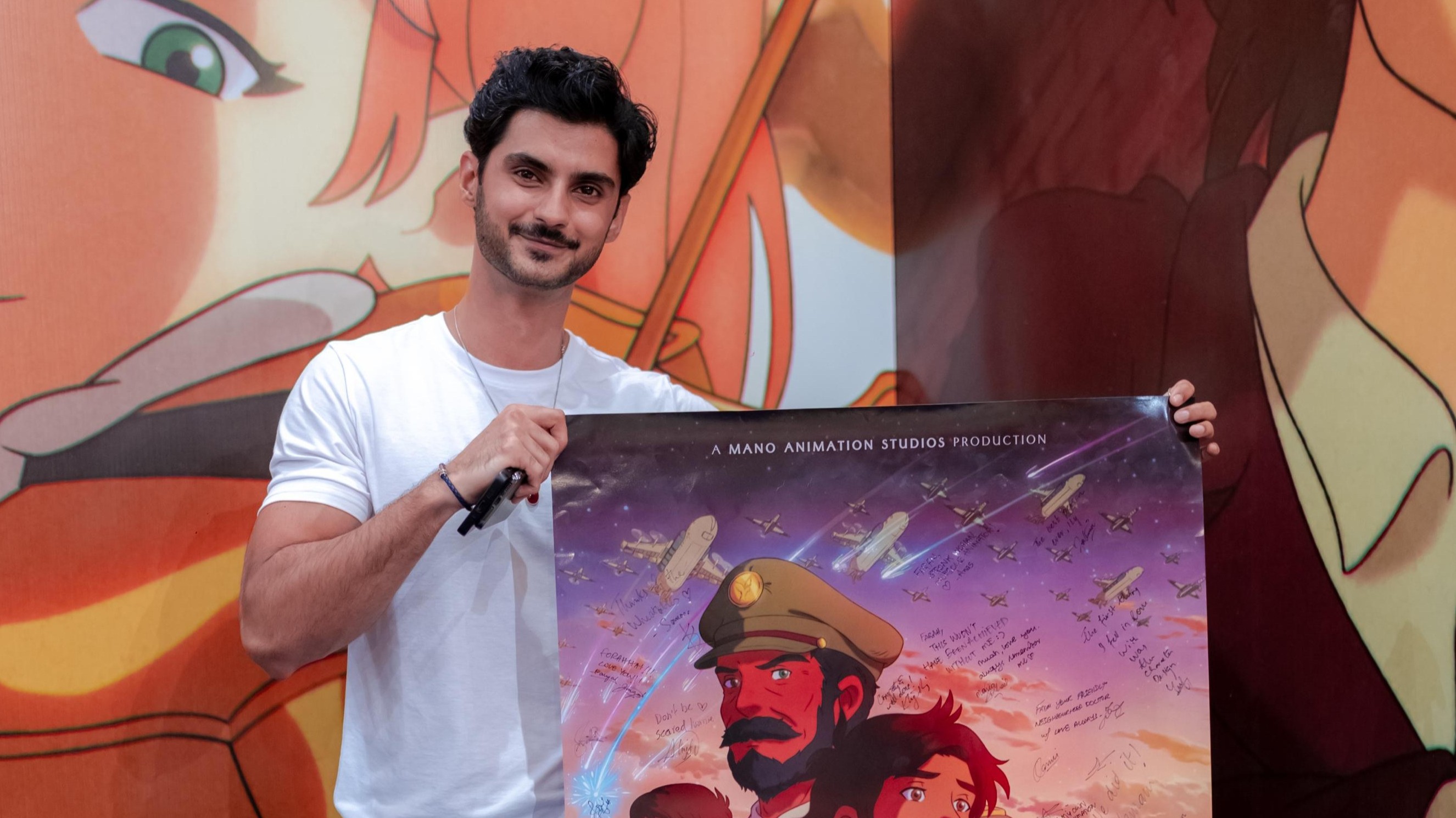 Sarim holding The Glassworker poster at an event